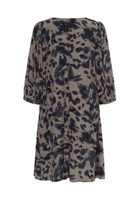 Une robe jusqu'au genou en tissu doux dans des tons neutres avec un motif abstrait bleu foncé et des manches bouffantes trois-quarts.