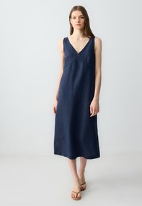Marineblaues Leinenkleid mit V-Ausschnitt, ärmellosem Design und leicht A-Linien-Silhouette, mit einem Reißverschlussdetail an der Vorderseite.