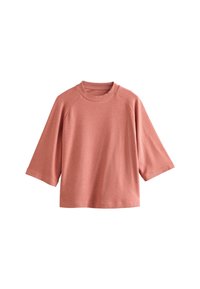 Haut à manches courtes rose clair avec encolure ronde côtelée et coupe détendue. Texture douce, motif uni, sans pièces métalliques apparentes.