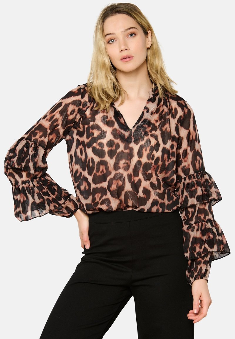 Blusa trasparente con stampa animale, caratterizzata da scollatura a V, maniche a volant e una vestibilità ampia. I colori includono beige, marrone e nero con un motivo a trama.
