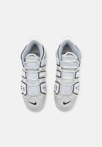 Witte sportieve schoenen van mesh en leer. Beschikt over verstelbare banden, opvallende branding en een getextureerde zool met zwarte accenten.