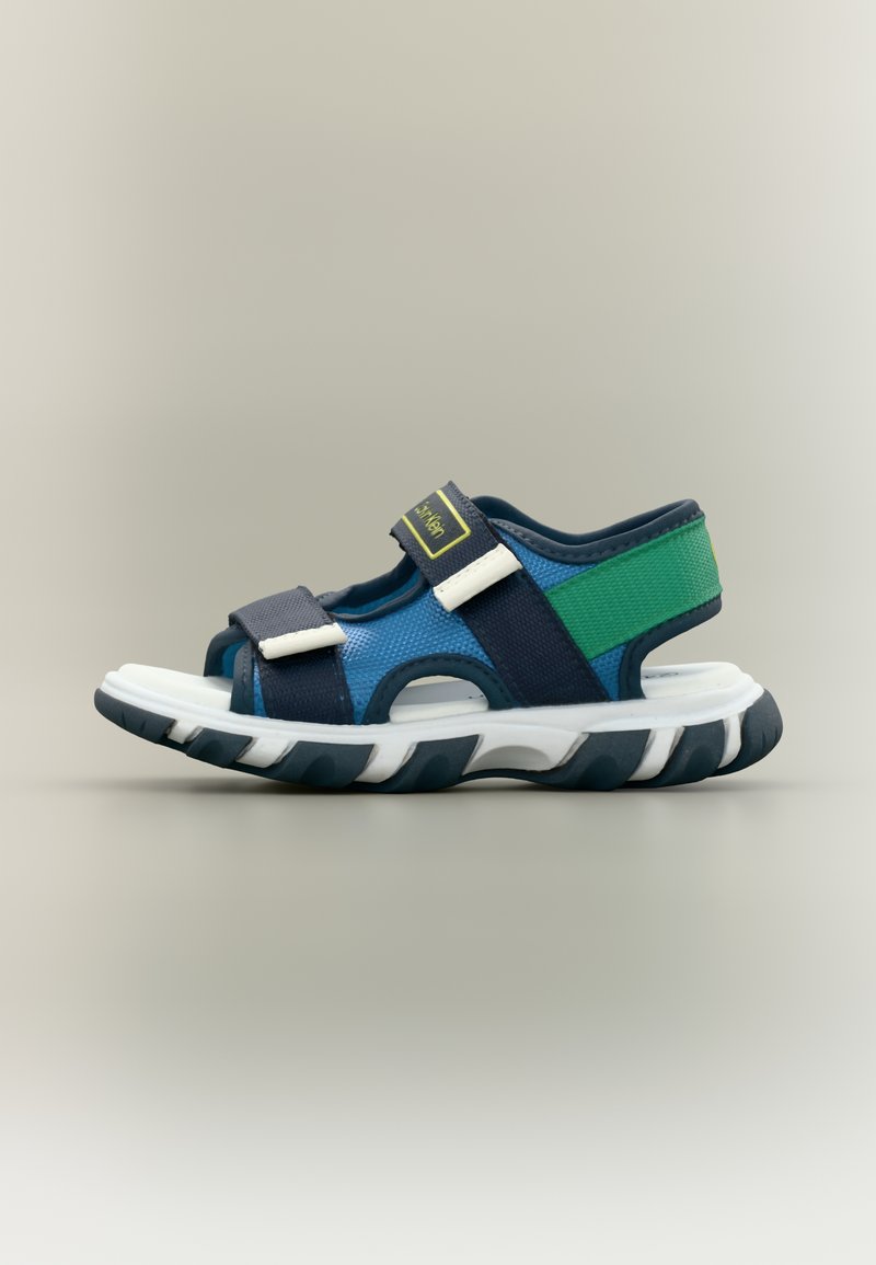 Παιδικό αθλητικό σανδάλι με μπλε, πράσινες και ναυτικές λουράκια, ρυθμιζόμενα κλείσιμο με βέλκρο και παχύ άσπρο και μαύρο πέλμα.
