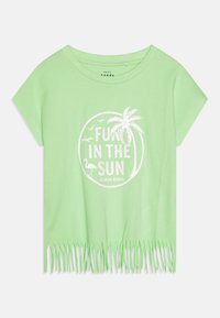 Helles grünes kurzes T-Shirt mit kurzen Ärmeln, das einen weißen Aufdruck mit der Aufschrift "FUN IN THE SUN", einem Palmenmotiv und einem fransigen Saumdetail zeigt.
