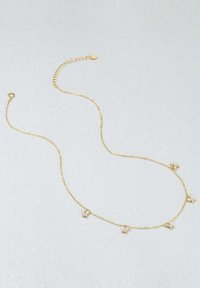 Collier en métal doré avec une chaîne délicate, mettant en valeur cinq petits accents en forme de papillon, chacun orné de pierres claires.