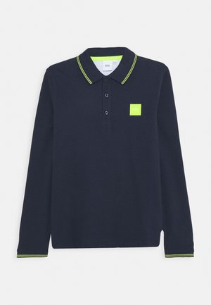 Langærmet sort polo med neon gul kant på krave og manchetter, tre knapper og en lille neon gul logo patch på brystet.