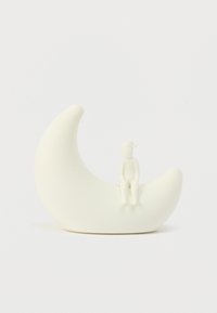 Στιλιζαρισμένο νυχτερινό φωτιστικό με σχήμα ημισελήνου σε ματ λευκό, με μια μικρή καθιστή φιγούρα από πάνω, όλα κατασκευασμένα από λείο πλαστικό.