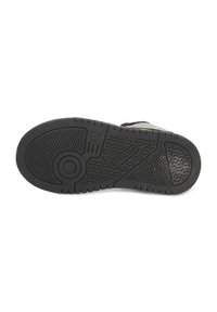 Zwarte rubberen sneakerzool met een patroon in de profiel, voorzien van een cirkelvormig embleem en het reliëf merknaam "BUNNIES" nabij de hak.