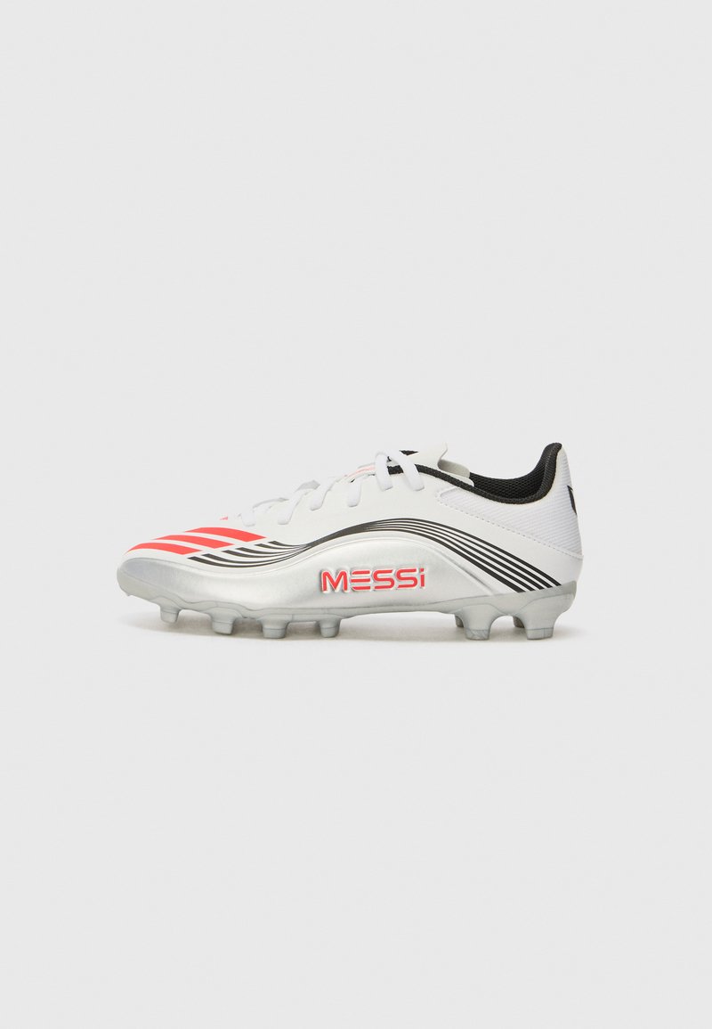 Witte voetbalschoenen met rode en zwarte accenten, logo met de tekst "MESSi" en een gestructureerde bovenkant. Bevat een gevormde zool met meerdere noppen.