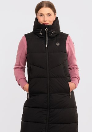 Chaleco acolchado negro con cuello alto y bolsillos con cremallera, que muestra una textura acolchada. Llevado sobre una blusa de manga larga rosa, que presenta un logo.