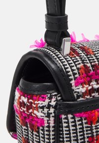 Una piccola borsa a tracolla in pelle nera è fissata con una tracolla in pelle nera, caratterizzata da un motivo intrecciato di fili neri, bianchi e colorati, con accenti rosa e arancioni.