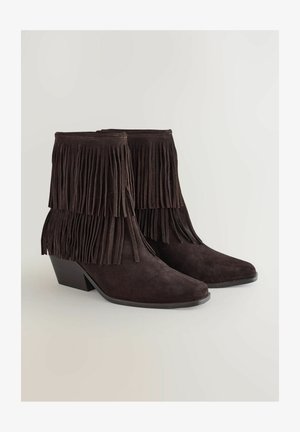 Stivali alla caviglia in suede marrone con dettaglio di frange, punta affusolata e tacco basso a blocco, con una finitura texturizzata e cuciture lisce.