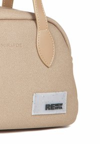 Beige stofhåndtaske med en tekstureret overflade, udstyret med læderhåndtag og et hvidt mærke med "RENEW VITA" i sort skrift.