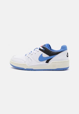 Biały niski sneaker marki Nike z niebieską podeszwą, niebieskimi i czarnymi akcentami, niebieskim logo Nike, białymi sznurowadłami oraz wyściełanym niebieskim kołnierzem widziany z boku.