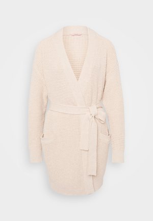 Cream-colored knitted cardigan with a wrap design, long sleeves, two front pockets, and a matching tie belt. Textured fabric, relaxed fit.