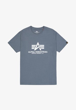 T-shirt gris en coton avec un logo central blanc portant le texte "ALPHA INDUSTRIES" et des rayures horizontales. Conception à manches courtes et col rond.