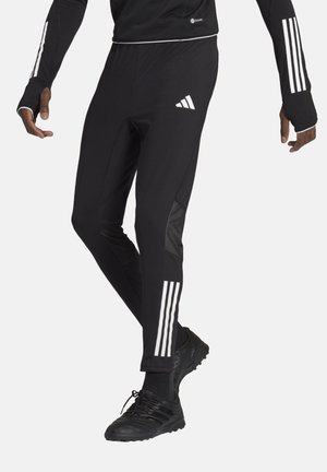 Schwarze Sporthose mit drei vertikalen weißen Streifen an den Seiten und einer figurnahen Passform. Hergestellt aus einem glatten, elastischen Material.
