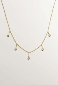 Collar de cadena de oro que presenta cinco colgantes circulares suspendidos, cada uno con una pequeña piedra clara, mostrando un diseño y textura delicados.