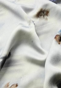 Könnyű, struktúrált szövet, lágy fényű. Fehér alapon finom, pasztell árnyalatú virágmintákkal díszített.