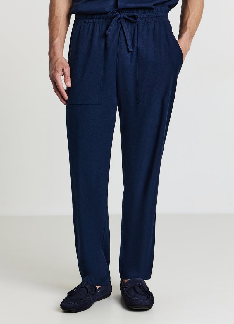 Pantalon de jogging bleu marine en tissu léger et lisse, doté d'une taille élastique avec cordon de serrage et deux poches avant.