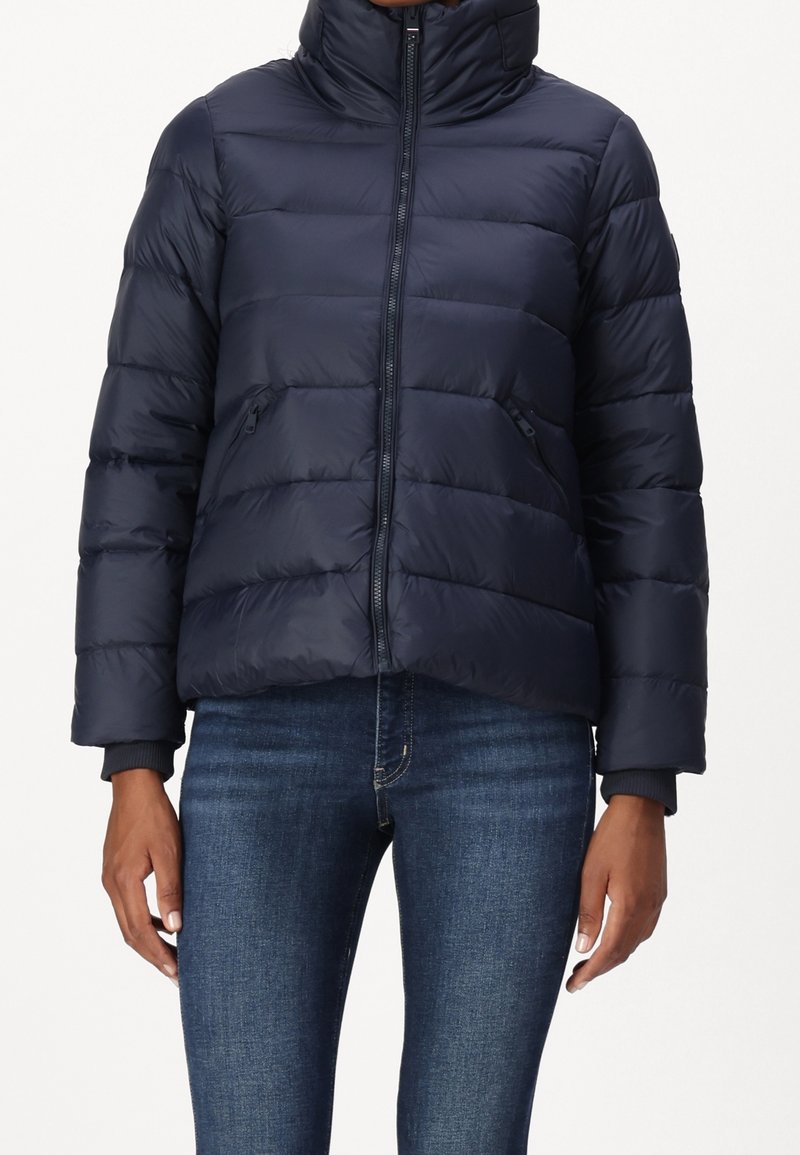 Giubbotto trapuntato navy con colletto alto, texture a righe orizzontali, zip frontale e tasche laterali. I polsini presentano dettagli a costine.