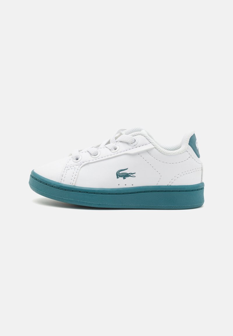 Sneaker bianca basse con suola, lacci e logo a coccodrillo color teal, vista dal lato esterno.