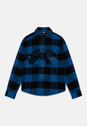 Camicia di flanella a quadri blu e nera con maniche lunghe, dotata di due tasche sul petto e chiusura con bottoni, realizzata in tessuto texturizzato.