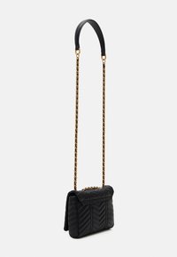 Black quilted shoulder bag with a leather top handle and gold chain strap. Features a chevron pattern and magnetic flap closure.