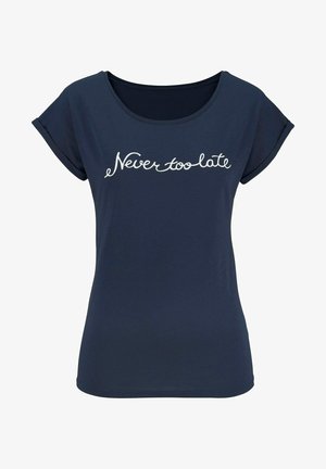 Marineblauw T-shirt van zachte stof, met een ronde halslijn en opgerolde korte mouwen; heeft op de voorkant witte cursieve tekst "Nooit te laat".