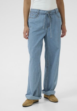 Modré pruhované nohavice s širokými nohavicami a sťahovacou šnúrkou v páse, s voľným strihom a preloženými manžetami. Vyrobené z mäkkej látky s jemným leskom.