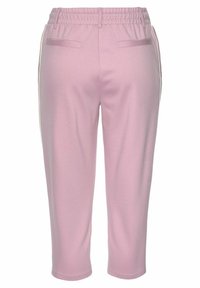 Lichtroze sweatpants met een elastische tailleband, twee achterzakken en zijstrepen. Gemaakt van zachte, rekbare stof.