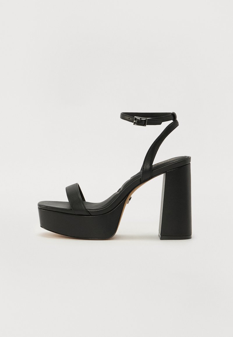 Sandale à plateforme noire avec un épais talon block, une fine bride au niveau de la cheville et une texture en cuir lisse. Design minimaliste avec orteils ouverts.