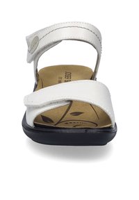 Hvide lædersandaler med justerbare remme, en mønstrede fodseng og en sort sål. Har en glat overflade og velcro-lukninger.