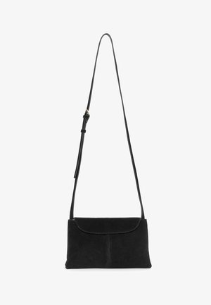Bolso de hombro de gamuza negra con una correa delgada ajustable y cierre de solapa, forma rectangular, diseño minimalista.
