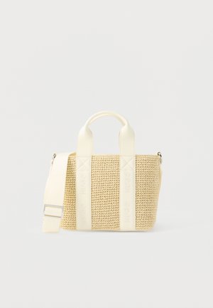 Bolso tote pequeño beige tejido con asas de cuero crema y correa de hombro ajustable sobre fondo blanco.