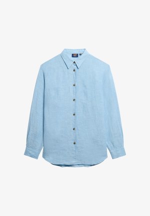 Lyseblå skjorte med knaplukning lavet af tekstureret stof. Har spidse kraver og syv brune knapper foran. Lange ærmer.