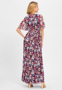 Maxi-jurk met vlindermouwen, voorzien van een kleurrijk abstract bloemmotief in rood, blauw en pink op een donkere achtergrond. Lichtgewicht stof.