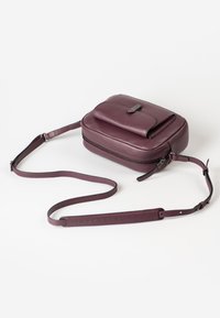 Burgunderfarbene Leder-Umhängetasche mit einem Reißverschluss-Hauptfach und einer Frontklappe. Mit verstellbarem Trageriemen und strukturiertem Finish.