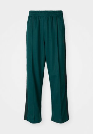 Pantalons de sport vert foncé avec une taille élastique, coupe droite et bandes noires sur les côtés. Fabriqués en tissu doux et extensible.