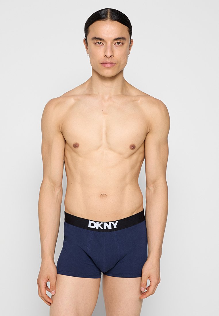 Granatowe bokserki z czarną gumką w pasie, na której znajduje się białe logo "DKNY". Gładki materiał, dopasowany krój i brak widocznych wzorów.