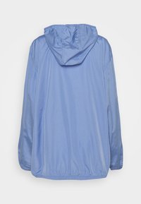 Jasnoniebieska, lekka kurtka z kapturem, elastycznym pasem i luźnymi rękawami; wykonana z gładkiego, wodoodpornego materiału.