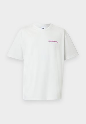 T-shirt blanc à manches courtes avec col rond et petit texte violet "All Conditions Gear" sur la poitrine gauche.