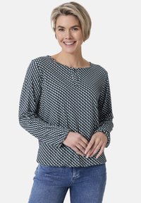 Langärmliges Oberteil im navyblauen und weißen geometrischen Muster, runder Ausschnitt, Knopfdetails am Kragen, weicher Stoff, der bequem über den Körper fällt.