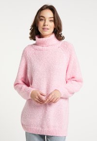 Suéter de punto rosa claro con un cuello alto acanalado. Patrón texturizado en toda la prenda, mangas largas y un corte relajado.