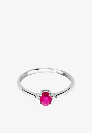 Silberner Ring mit einem ovalen Rubin in der Mitte, flankiert von kleinen klaren Steinen. Glatte, polierte Band mit einem eleganten Design.