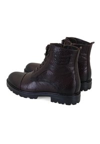 Bruine leren enkelboots met een gestructureerde afwerking, ronde neus, vetersluiting aan de voorkant en stevige zwarte rubberen zool. Aanwezigheid van zijkanten.