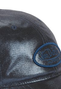 Casquette bleue et noire avec une texture brillante, présentant un patch logo brodé rond et des détails de couture le long de la visière.