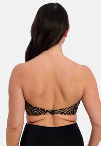 Sujetador bandeau con patrón de cebra en negro y marrón, con cierre de broche, hecho de una tela suave; sin almohadillas, diseñado para ajustarse cómodamente.