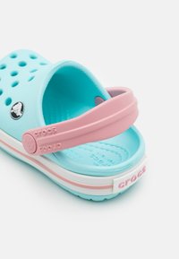 Blue and pink rubber sandal featuring ventilation holes, a strap, and a white midsole with "CROCS" logo on the heel.