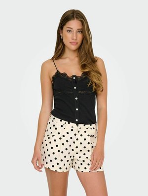 Svart cami med spetsdetaljer och knappar, tillsammans med krämfärgade shorts i svart prickmönster. Båda plaggen har en klassisk och avslappnad design.