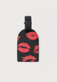 Etichetta per bagagli in pelle nera con impronte di baci di rossetto rosso e testo dorato "VALENTINO" in basso. Parte superiore arrotondata con un'asola per il fissaggio.